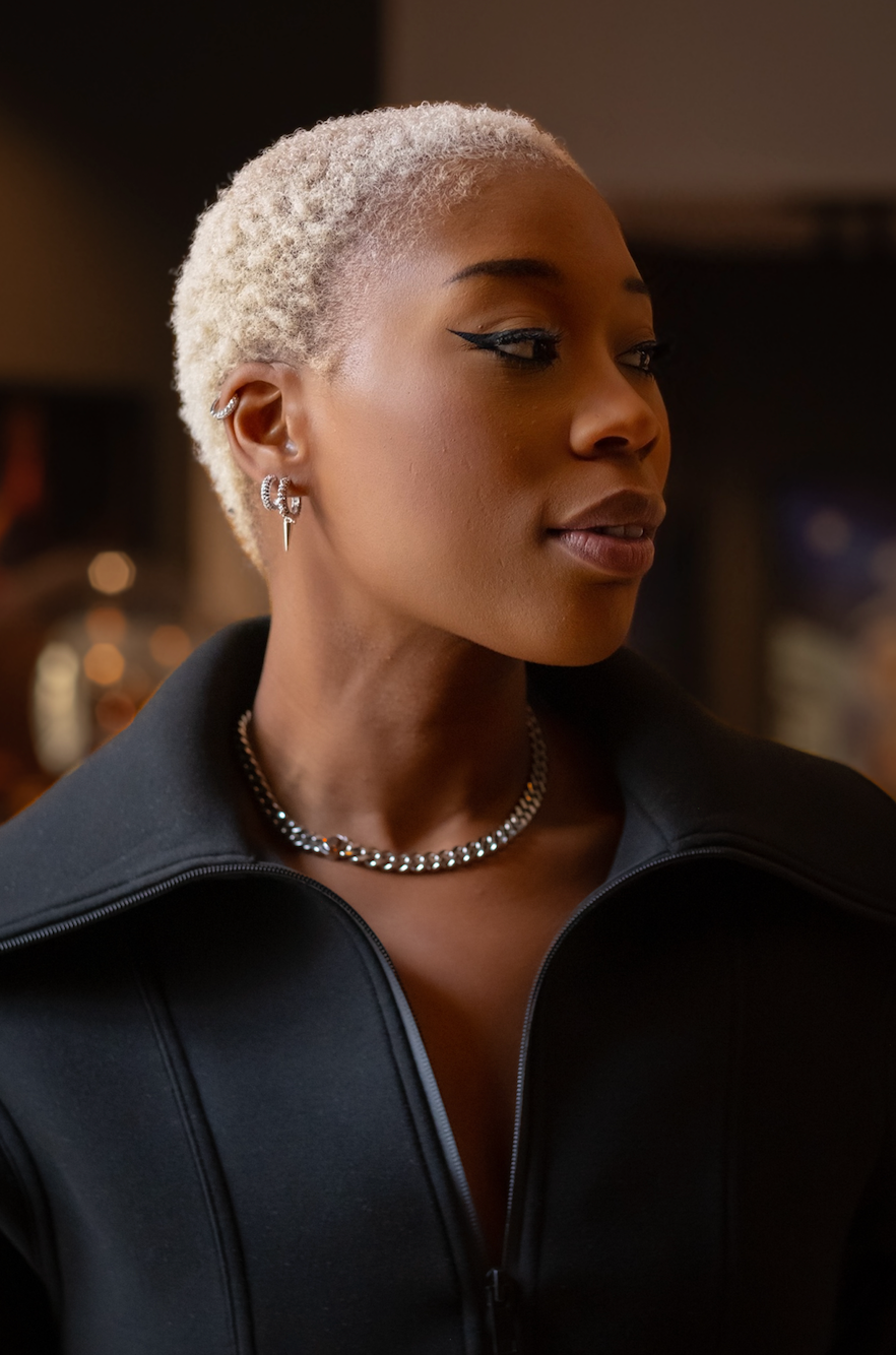 Modell bär tjockt kedjehalsband i rostfritt stål med brun kubisk zirkona-sten