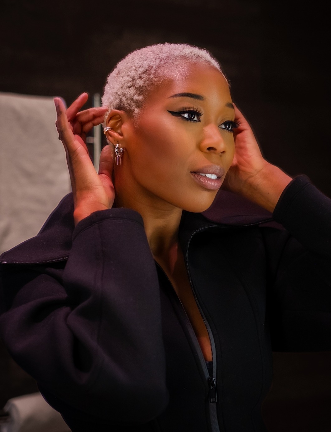 Modell bär silverhoops med nitar och gröna glittrande kubiska zirkonia-stenar 