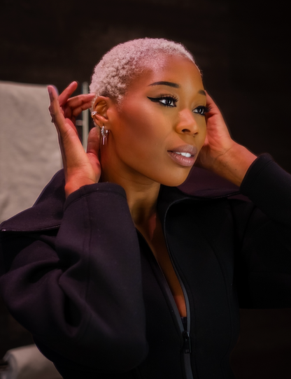 Modell bär silverhoops med nitar och gröna glittrande kubiska zirkonia-stenar 