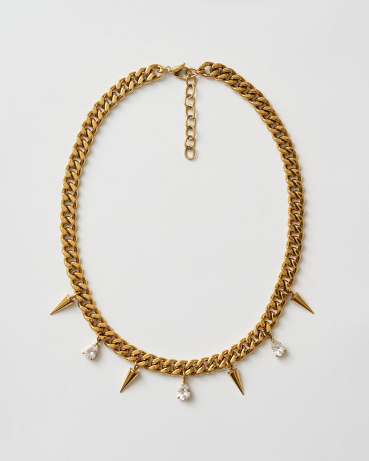 Guldhalsband med nitar och vita kubiska zirkonia-stenar fotad uppifrån
