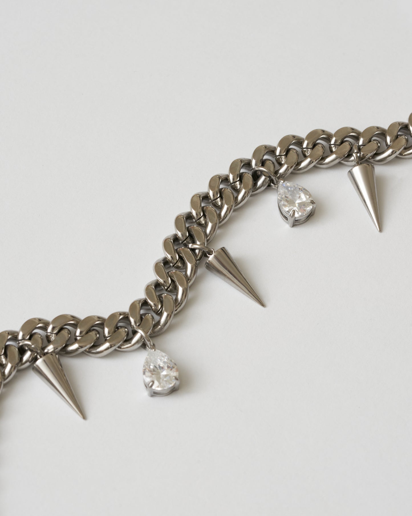 Silverhalsband med nitar och vita kubiska zirkonia-stenar fotad nära