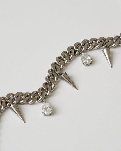 Silverhalsband med nitar och vita kubiska zirkonia-stenar fotad nära