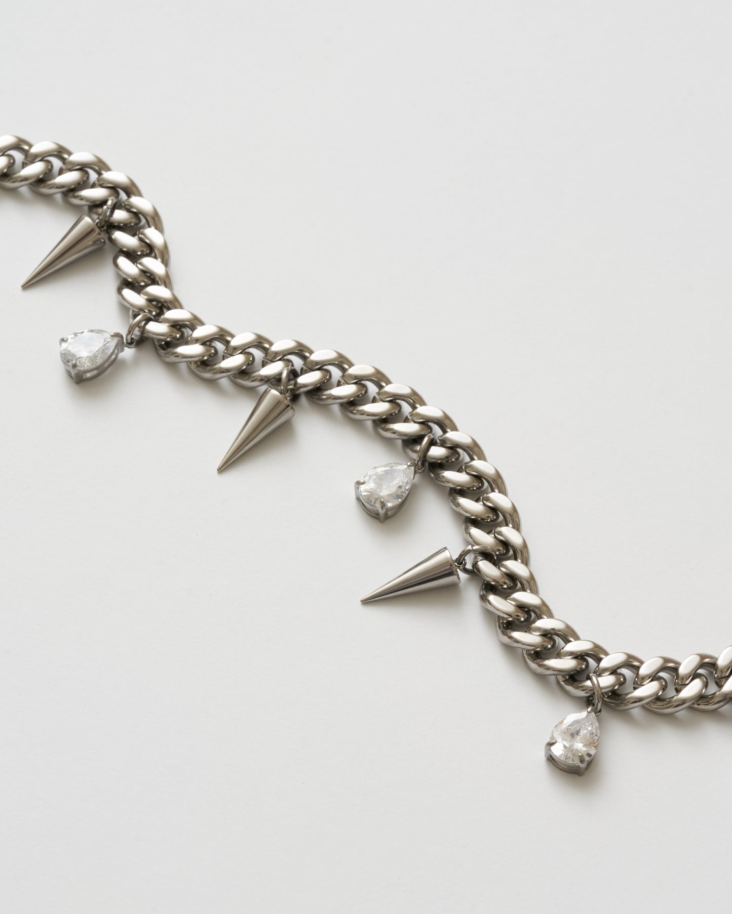 Närbild på detaljer på silverhalsband med nitar och vita kubiska zirkonia-stenar