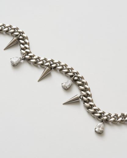 Närbild på detaljer på silverhalsband med nitar och vita kubiska zirkonia-stenar