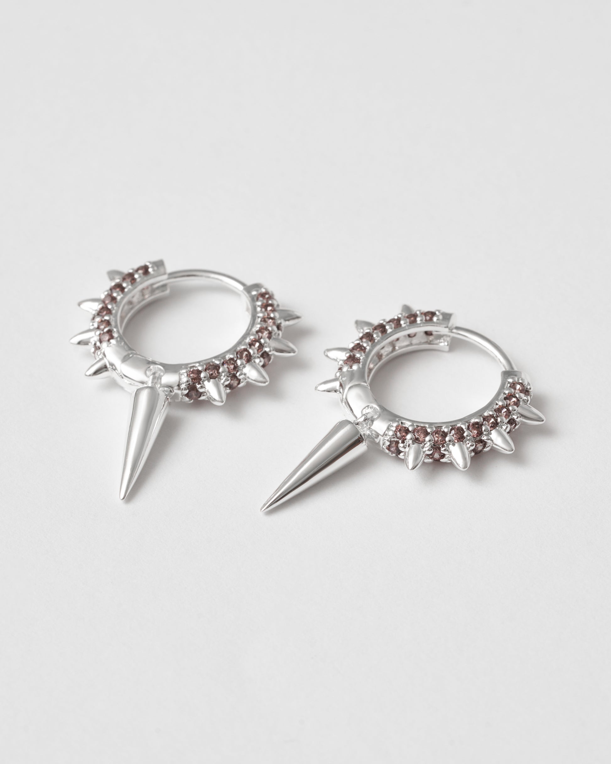 Bruna zirkoner på silver hoops med spikdetaljer – varm kontrast
