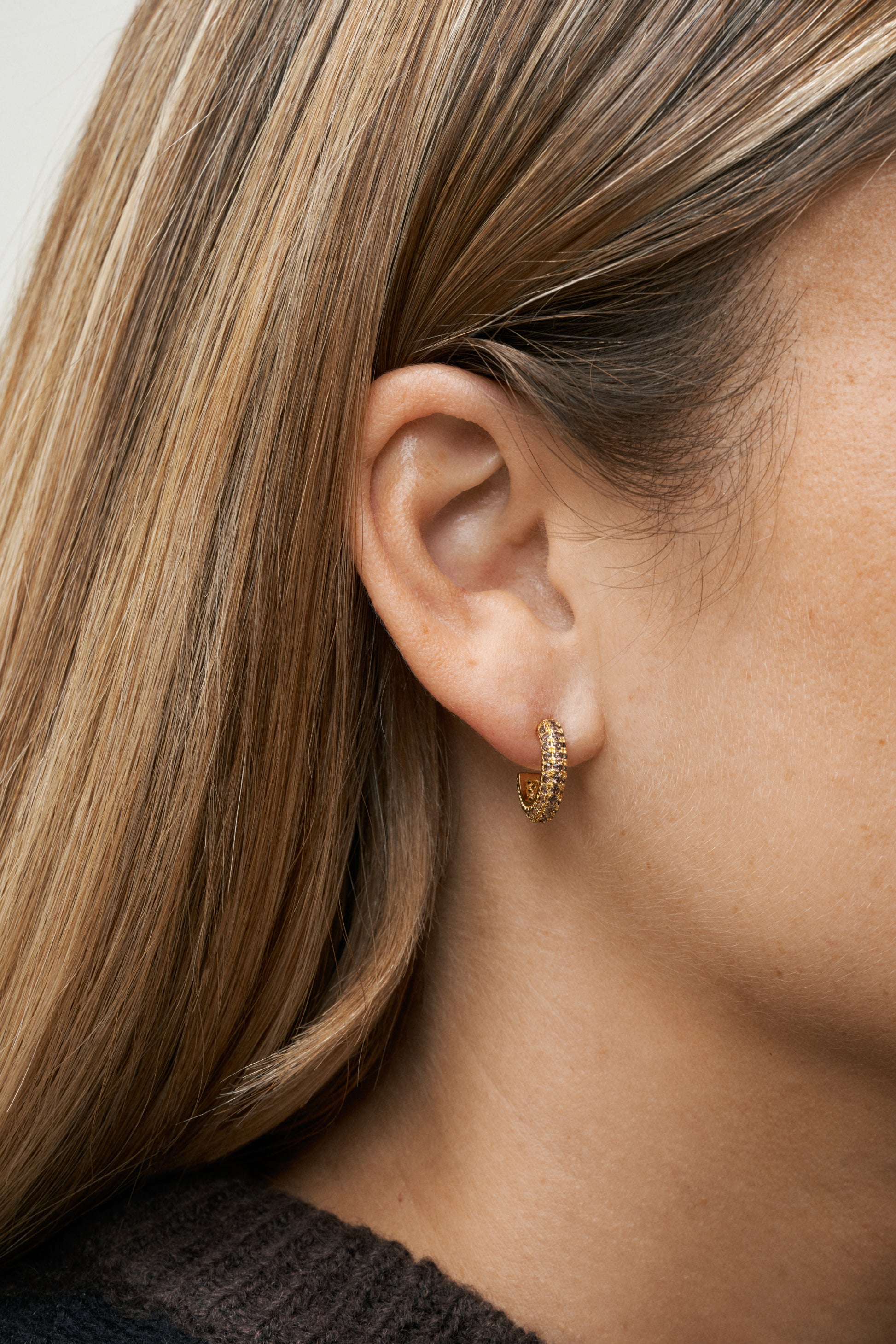 Guldpläterade hoops med varma bruna zirkoner, modellbild på öra