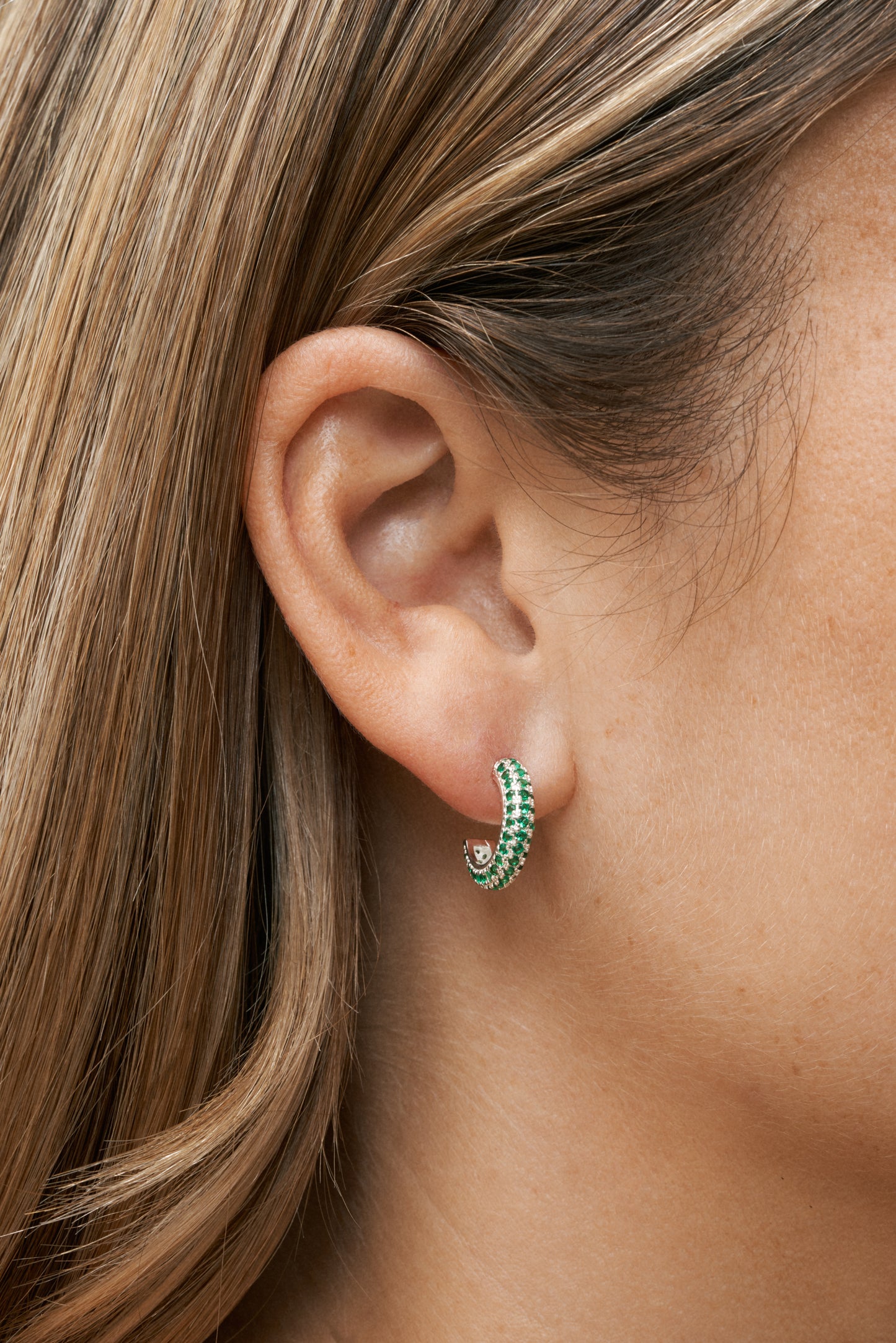 Sterling silver hoops med gröna zirkonstenar – modern klassiker. Närbild på öra